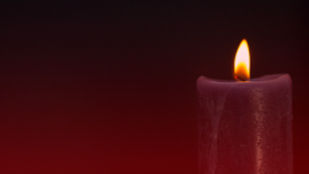 Vela vermelha acesa em um fundo escuro com toneladas de sangue vermelho, simbolizando o poder espiritual das rezas poderosas da Quimbanda