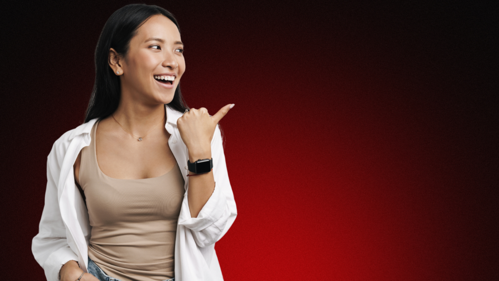 Imagem de uma mulher sorridente apontando para o lado, transmitindo positividade e confiança. O fundo escuro com tons avermelhados cria um contraste que destaca sua expressão alegre e acolhedora, simbolizando superação da insegurança no relacionamento e crescimento emocional.