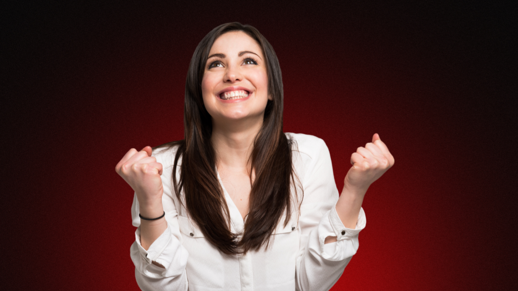 Imagem de uma mulher sorridente apontando para o lado, transmitindo confiança e leveza. Sua expressão alegre simboliza segurança emocional e autoestima fortalecida, destacando um estado de bem-estar após superar.