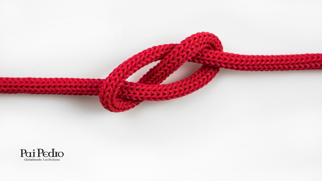 Corda vermelha grossa formando um nó firme sobre fundo branco, simbolizando união, vínculo forte e amarração. A imagem transmite estabilidade e conexão intensa, representando a ideia de fortalecimento de laços afetivos, depois de sonhar com separação.