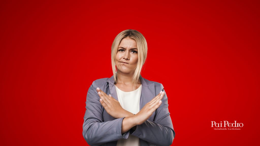 Mulher loira com expressão séria e braços cruzados em X na frente do corpo, em sinal de recusa ou rompimento, representando a decisão de parar de agradar a todos.