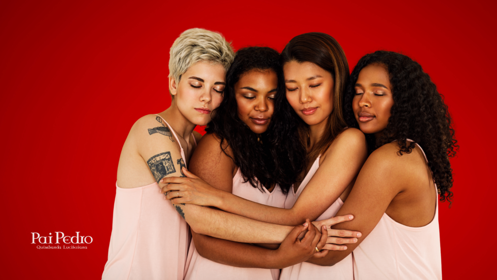 Quatro mulheres de diferentes etnias se abraçam com os olhos fechados, transmitindo acolhimento, empatia e união feminina, depois do Relacionamento Extraconjugal. Todas vestem roupas suaves em tom rosa claro. O fundo vermelho vibrante intensifica a força emocional da imagem. No canto inferior esquerdo, está a marca "Pai Pedro – Quimbanda Luciferiana".