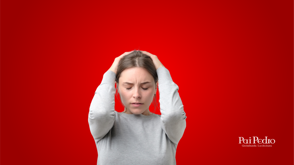 Mulher jovem de olhos fechados, com expressão de angústia e as mãos pressionando a cabeça, transmitindo sofrimento emocional. O fundo vermelho vibrante reforça a intensidade da dor e da confusão mental associada à dificuldade de como esquecer alguém. 