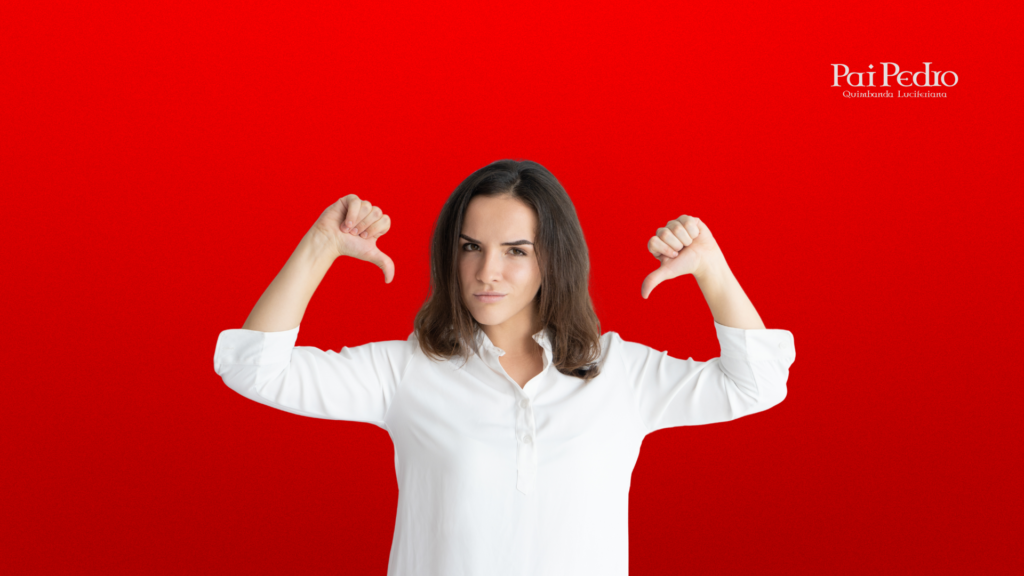 Mulher séria com expressão de decisão, vestindo camisa branca, olhando diretamente para a câmera enquanto aponta os dois polegares para baixo em sinal de Se Afastar é a Melhor Solução. Fundo vermelho vibrante com o logo “Pai Pedro – Quimbanda Luciferiana” no canto superior direito. A imagem transmite ruptura, rejeição e tomada de posição.