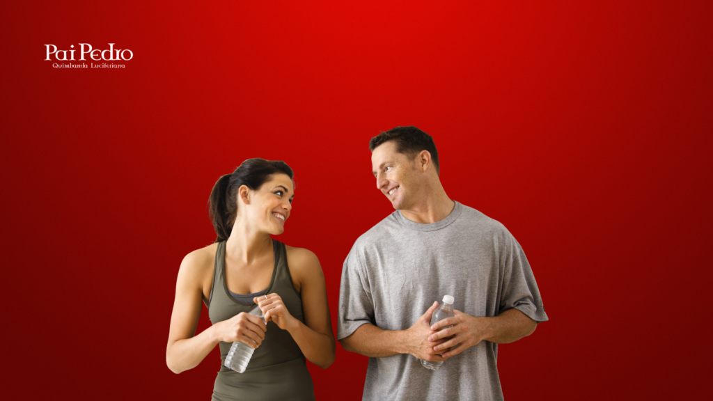 Homem e mulher trocam olhares sorridentes enquanto seguram garrafas de água, transmitindo leveza e naturalidade na interação, simbolizando como fazer a conversa fluir sem esforço.