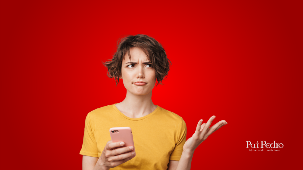 Mulher de camiseta amarela olha desconfiada para o celular, com expressão de dúvida e incômodo, sobre fundo vermelho, transmitindo as desvantagens do relacionamento LAT.