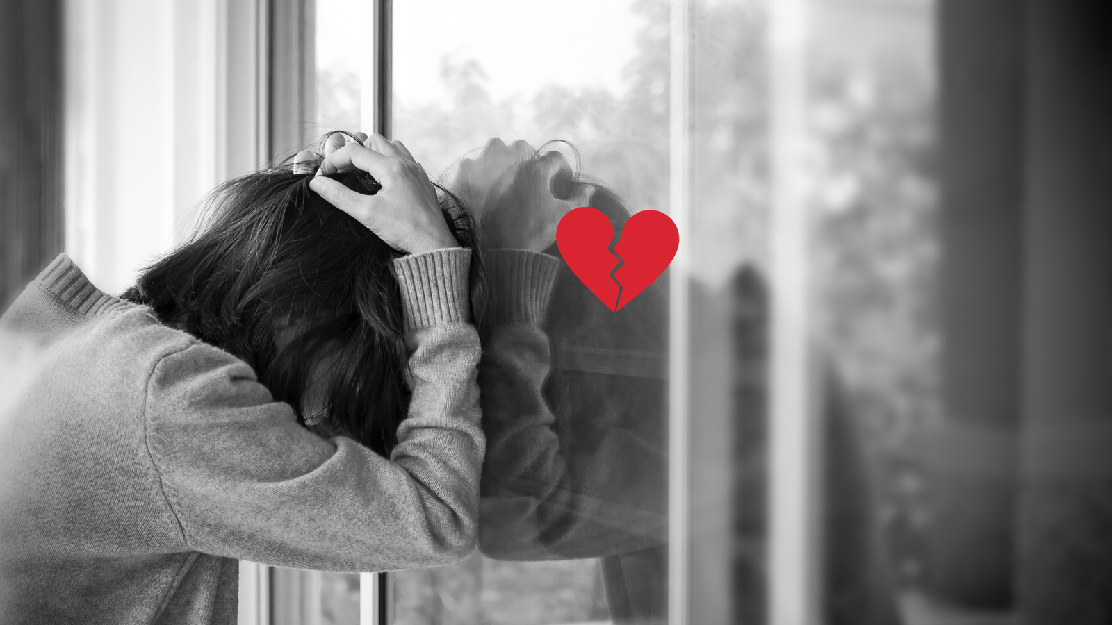 Uma imagem preta e branca, de uma mulher encostando a cabeça no vidro, ela simboliza a tristeza porque Amarração amorosa não funciona para trazer ex de volta