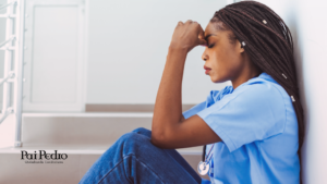 Mulher sentada no chão, visivelmente exausta e emocionalmente abalada, representando o impacto de um relacionamento desgastado na vida pessoal e profissional.