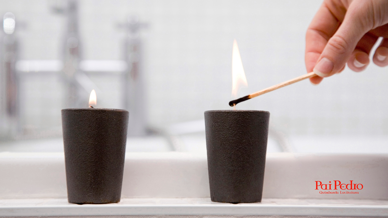 Pessoa acendendo duas velas pretas com fósforo sobre uma superfície branca, representando um ritual de fortalecimento espiritual para conexão com o anjo da guarda.