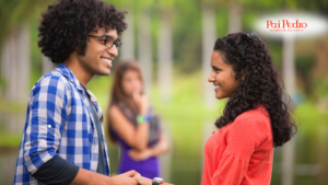 Casal feliz de mãos dadas enquanto uma mulher observa ao fundo com expressão suspeita, simbolizando a presença de uma mulher talarica.